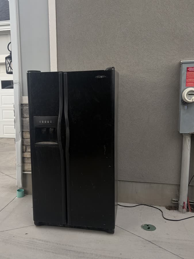 A side-by-side fridge left beside a driveway for Instahaul single item pickup.